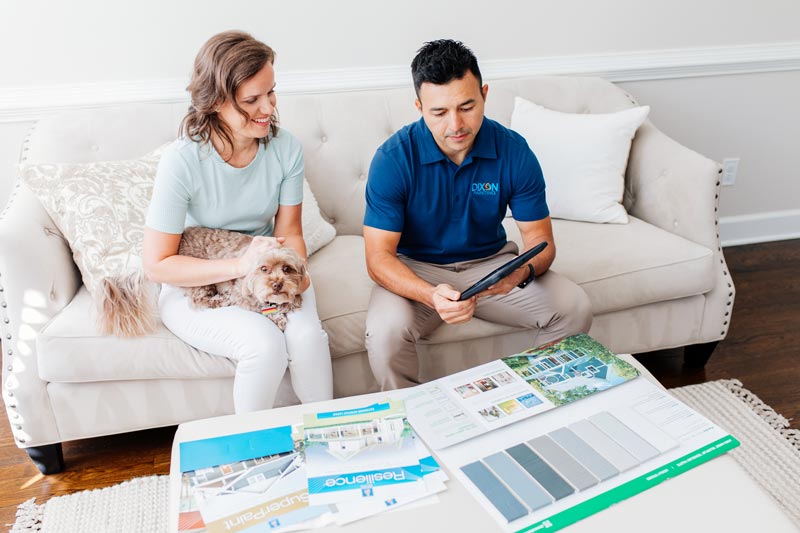 Dixon Painting expert showing paint samples to a woman with a dog in her lap in Atlanta, GA