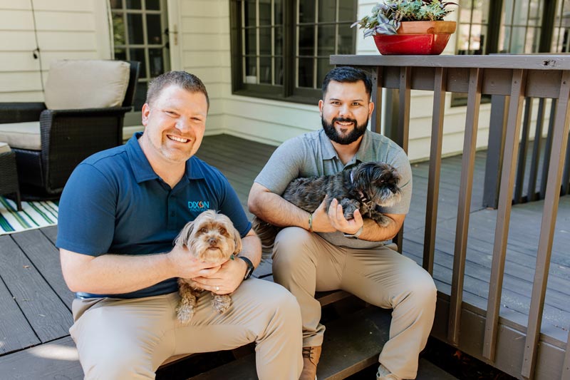Dixon painting experts posing with dogs on a freshly painted deck in Atlanta, GA