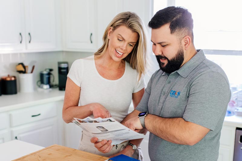 Dixon Painting team member discussing brochure with a client in her Atlanta and Marietta, GA home