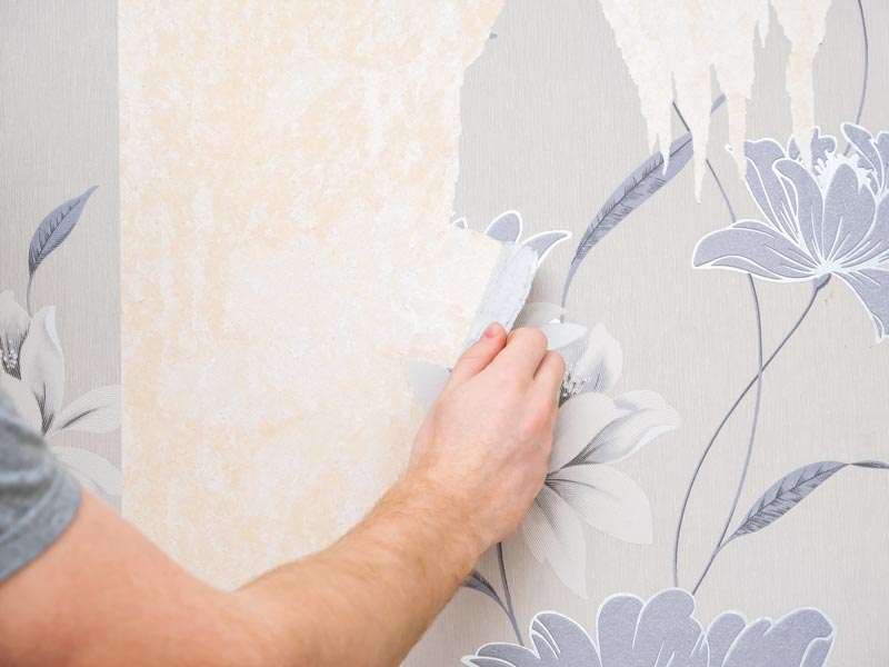 A professional is removing the wallpaper of a house in Atlanta and Roswell, GA.