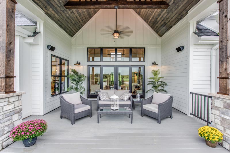 Wicker furniture and a ceiling fan adorn a covered porch in Marietta, GA