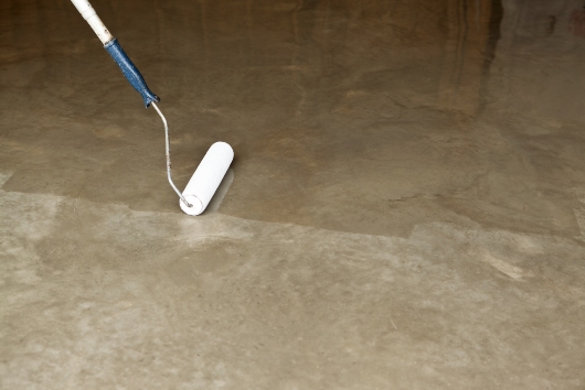 A professional of the Dixon Painting team rolling a concrete stain on the floor in Atlanta, GA
