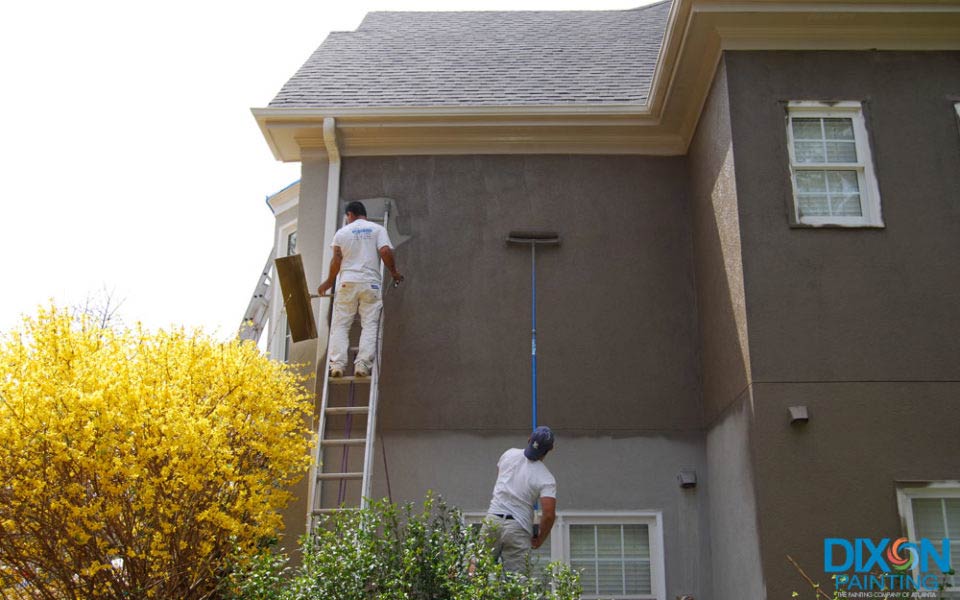 Two men using a ladder to paint the exterior of a house in Marietta and Atlanta, GA
