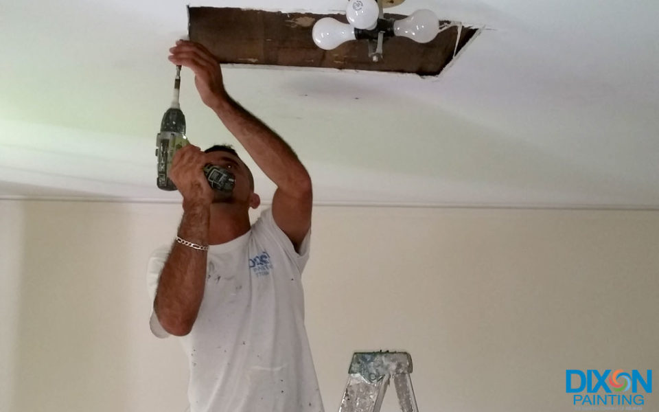 A man using a drill to work on a ceiling in Atlanta and Kennesaw, GA

