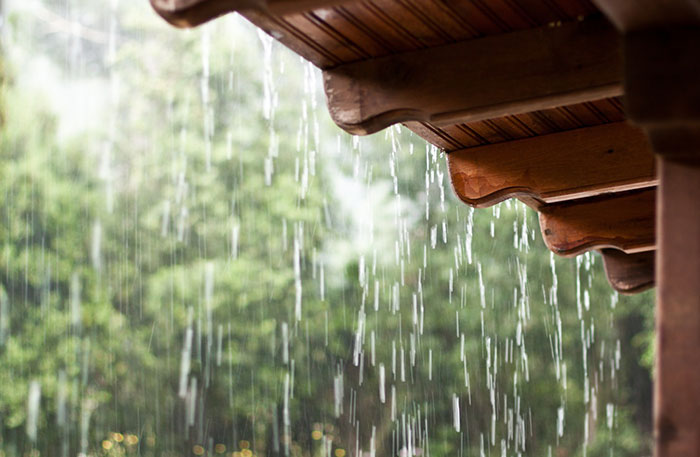 Rain pours outside the house, showcasing the need for gutter repair in Atlanta and Roswell, GA.