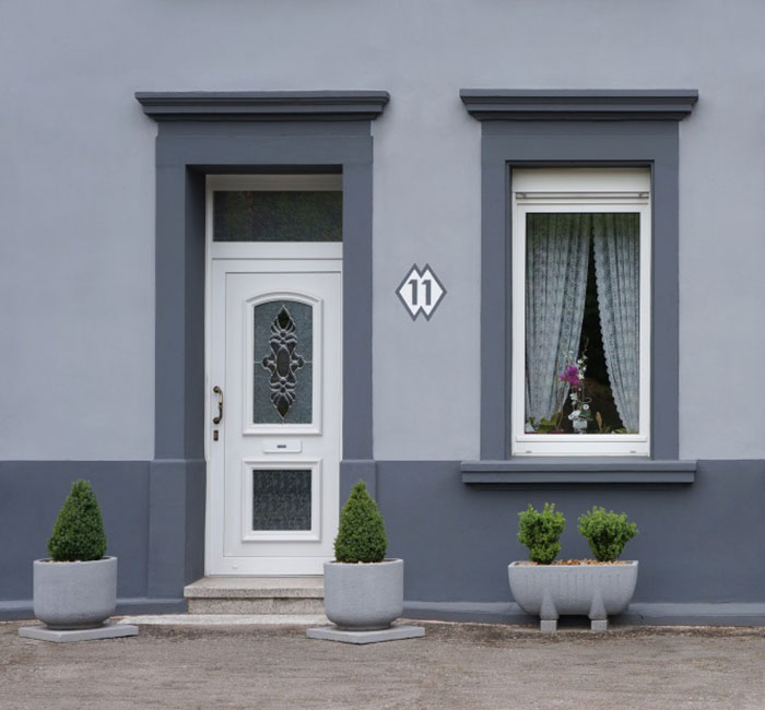 A gray house with a white door and two planters in Atlanta and Kennesaw, GA